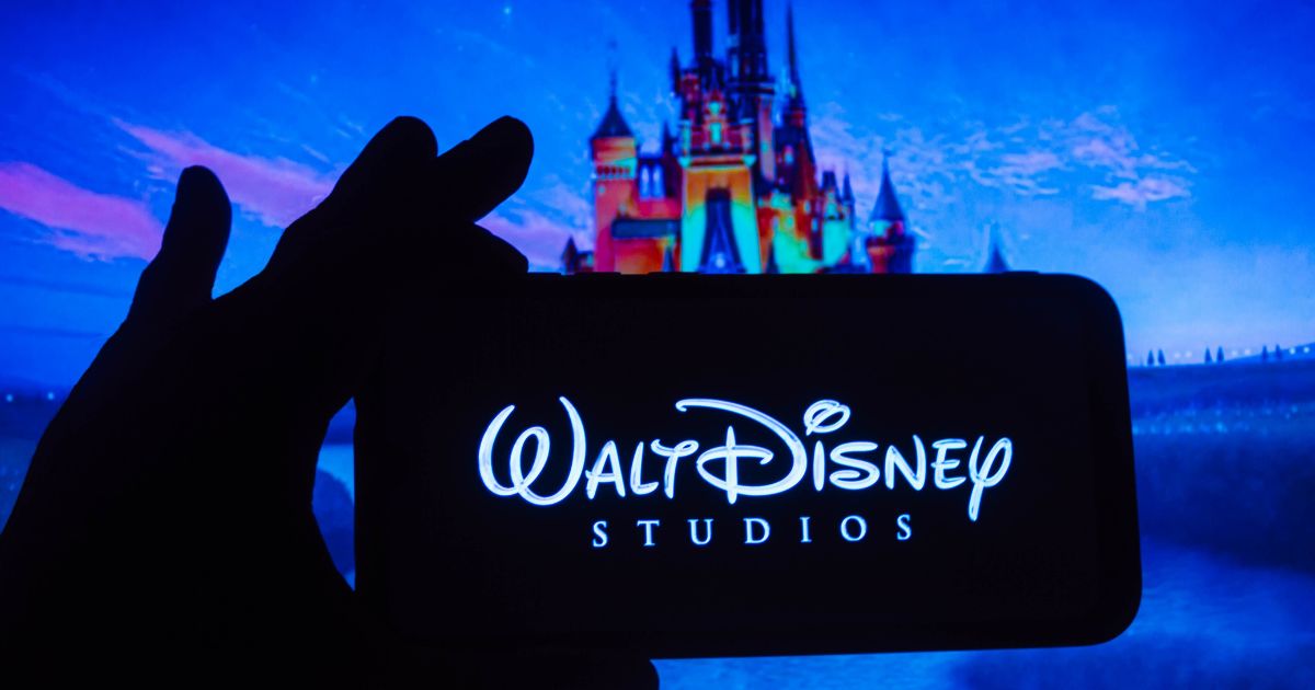 A photo illustration shows the Walt Disney Studios logo on a smartphone on Oct. 26, 2021.
