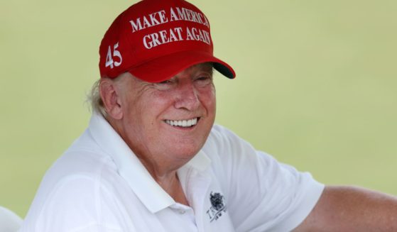 Former President Donald Trump sits in his golf cart on the ninth hole waiting to tee off during the LIV Golf Invitational - Bedminster at Trump National Golf Club Bedminster in Bedminster, New Jersey, on Thursday.