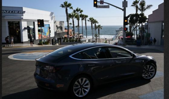 A Tesla electric vehicle makes a turn in Manhattan Beach, California. The state is expected to ban the sale of new gasoline vehicles starting in 2035.
