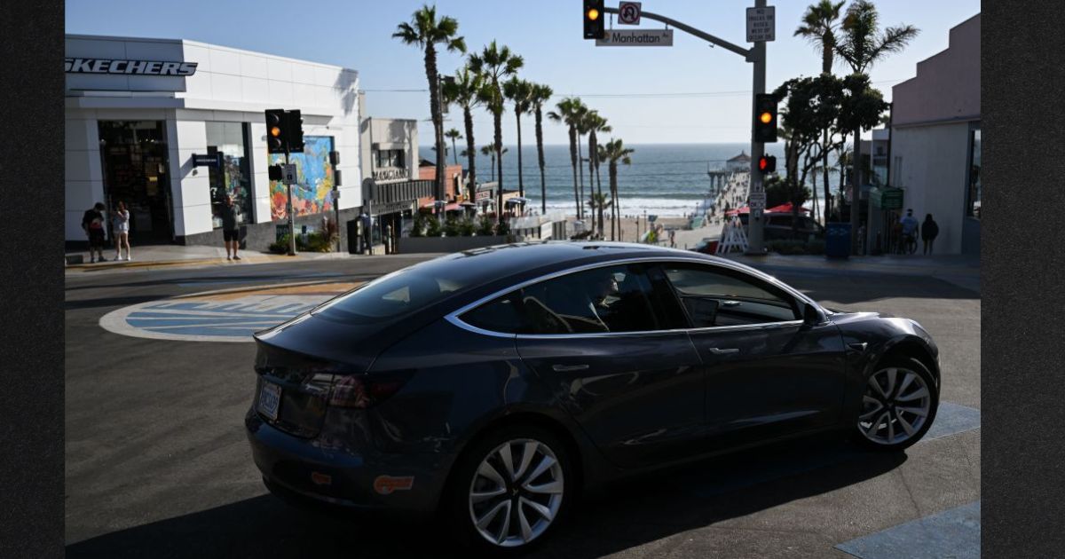 A Tesla electric vehicle makes a turn in Manhattan Beach, California. The state is expected to ban the sale of new gasoline vehicles starting in 2035.