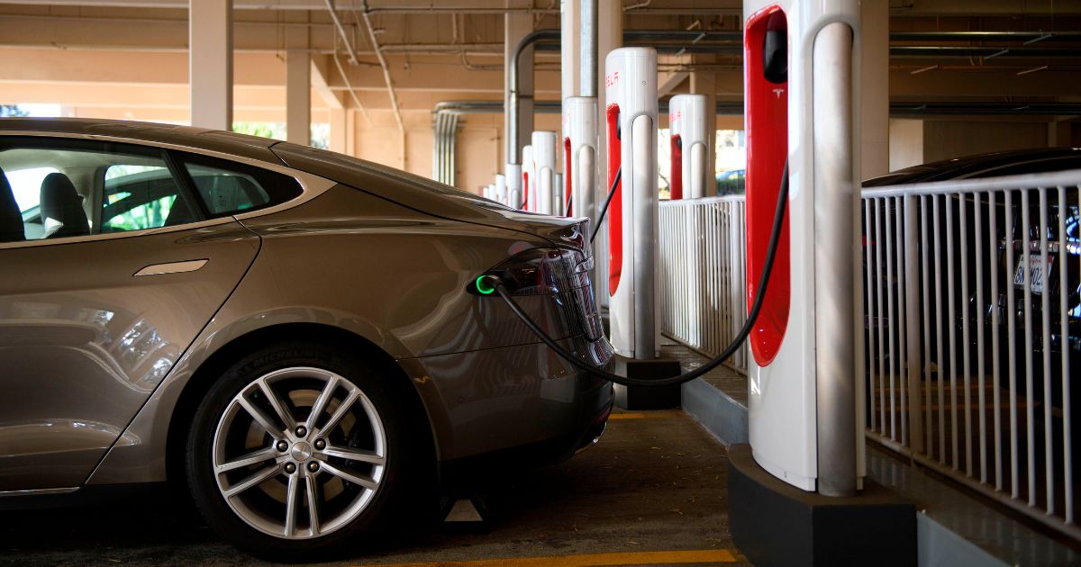 A Tesla electric vehicle charges at a supercharger station in Redondo Beach, California, on Jan. 4, 2021.