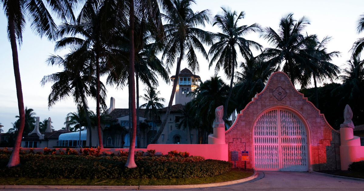 Police lights reflect on the entrance to former President Donald Trump's Mar-a-Lago estate on Aug. 8.