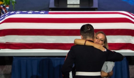 Shana Chappell, the mother of slain Lance Cpl. Kareem Nikoui, hugs a Marine next to the flag-draped casket of her son during a funeral at the Harvest Christian Fellowship in Riverside, California, on Sept. 18, 2021.