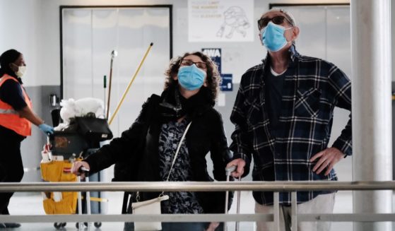 Travelers and employees wear masks at John F. Kennedy Airport in New York on April 19.
