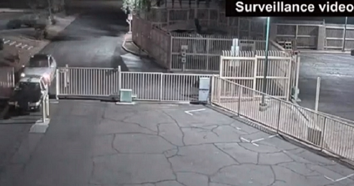 A surveillance video screen shot shows an SUV ramming a police vehicle from behind.