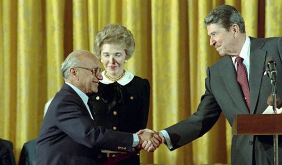 Milton Friedman shakes hands with President Ronald Reagan in the East Room of the White House on Oct. 17, 1988.