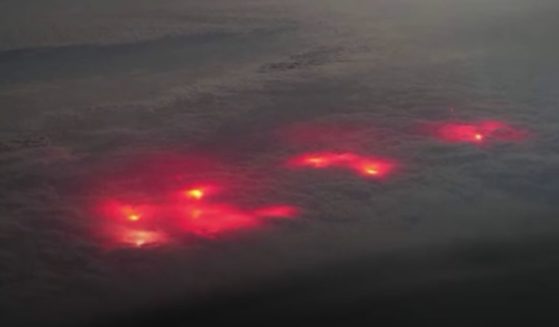 A pilot captured images of red lights beneath the clouds.