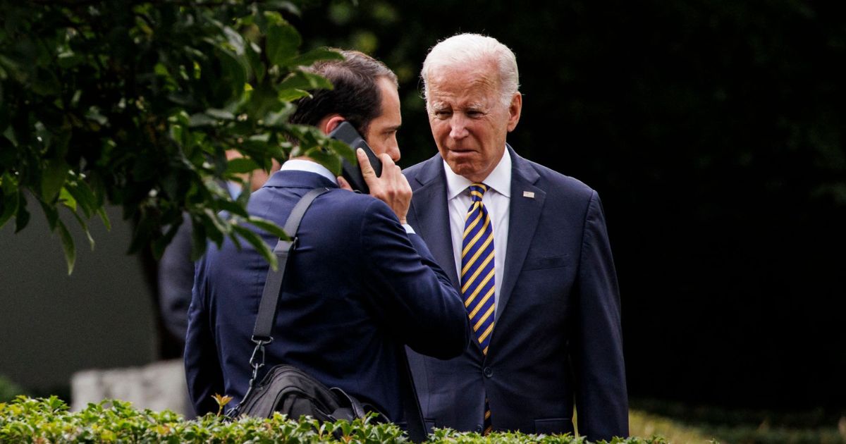 Special Assistant and Personal Aide to the President Stephen Goepfert, left, speaks to President Joe Biden, right, in the Jacqueline Kennedy Garden of the White House on July 6.