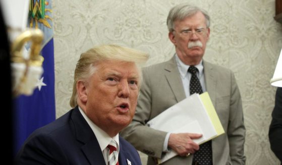 Then-President Donald Trump and his national security advisor, John Bolton, meet with Romanian President Klaus Iohannis in the Oval Office of the White House in Washington on Aug. 20, 2019.