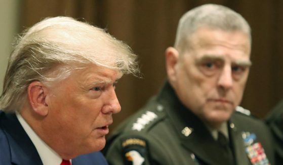 Then-President Donald Trump, left, speaks as Joint Chiefs of Staff Chairman Gen. Mark Milley watches, following a briefing from senior military leaders in the Cabinet Room of the White House in Washington, D.C., on Oct. 7, 2019.