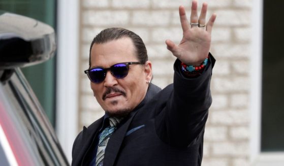 Actor Johnny Depp waves to fans after arriving at the Fairfax County, Virginia, Courthouse on May 25 during his defamation trial against his ex-wife, actress Amber Heard.