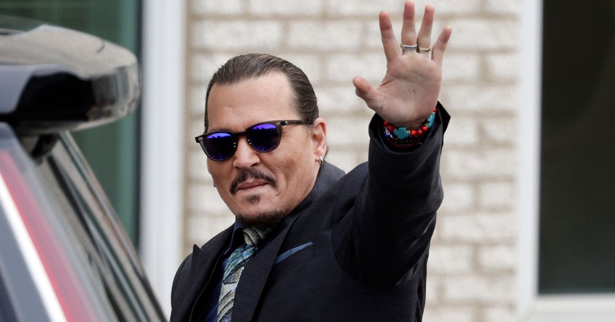Actor Johnny Depp waves to fans after arriving at the Fairfax County, Virginia, Courthouse on May 25 during his defamation trial against his ex-wife, actress Amber Heard.