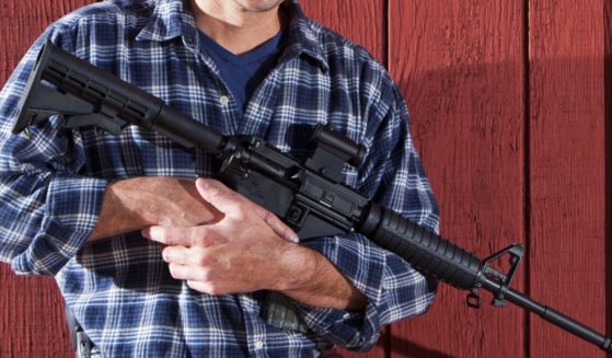 A man's torso, holding an AR-15.