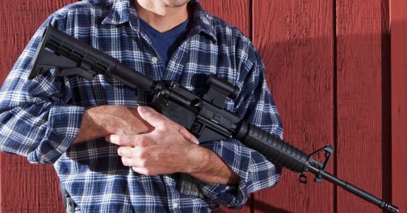 A man's torso, holding an AR-15.