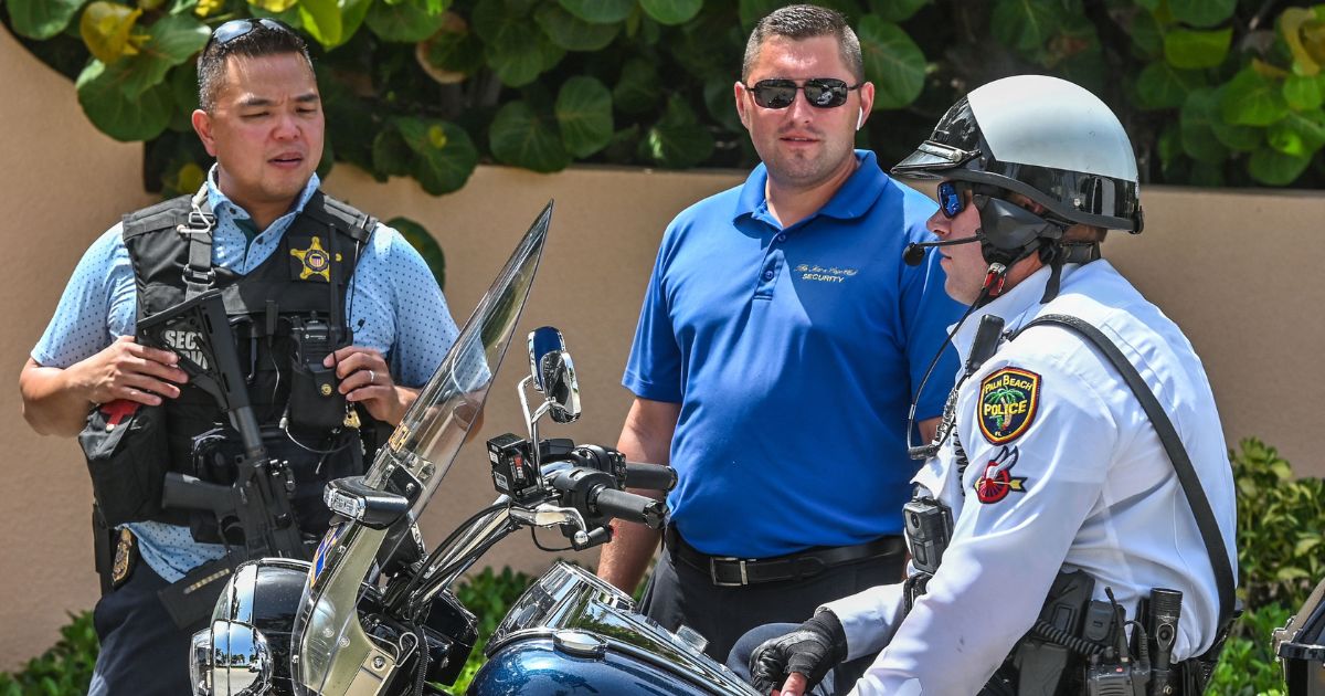 Secret Service and local law enforcement officers stand in front of the home of former President Donald Trump at Mar-a-Lago in Palm Beach County, Florida, on Tuesday. The president's home was raided Monday by FBI agents.