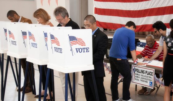 A stock photo of voters at the polls.