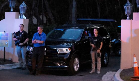 Armed Secret Service agents stand outside an entrance to former President Donald Trump's Mar-a-Lago Club estate in South Florida the evening of Aug. 8, the day of the FBI's raid.