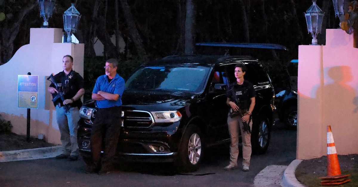 Armed Secret Service agents stand outside an entrance to former President Donald Trump's Mar-a-Lago Club estate in South Florida the evening of Aug. 8, the day of the FBI's raid.