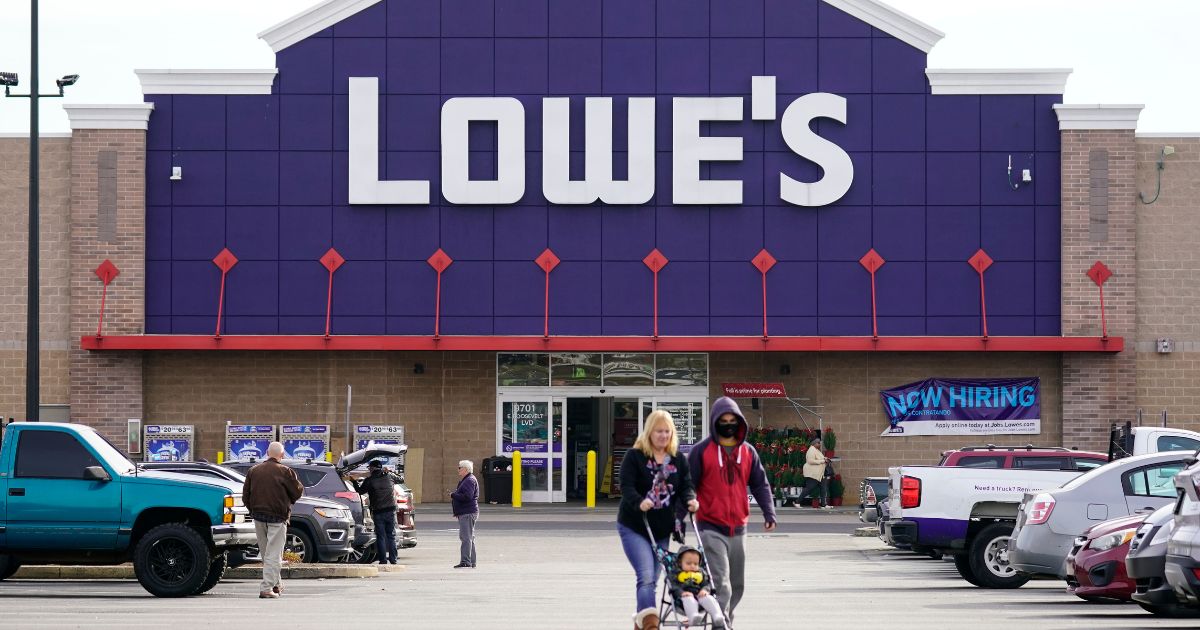 Shoppers walk in the parking lot of a Lowe's home improvement store in Philadelphia last November.