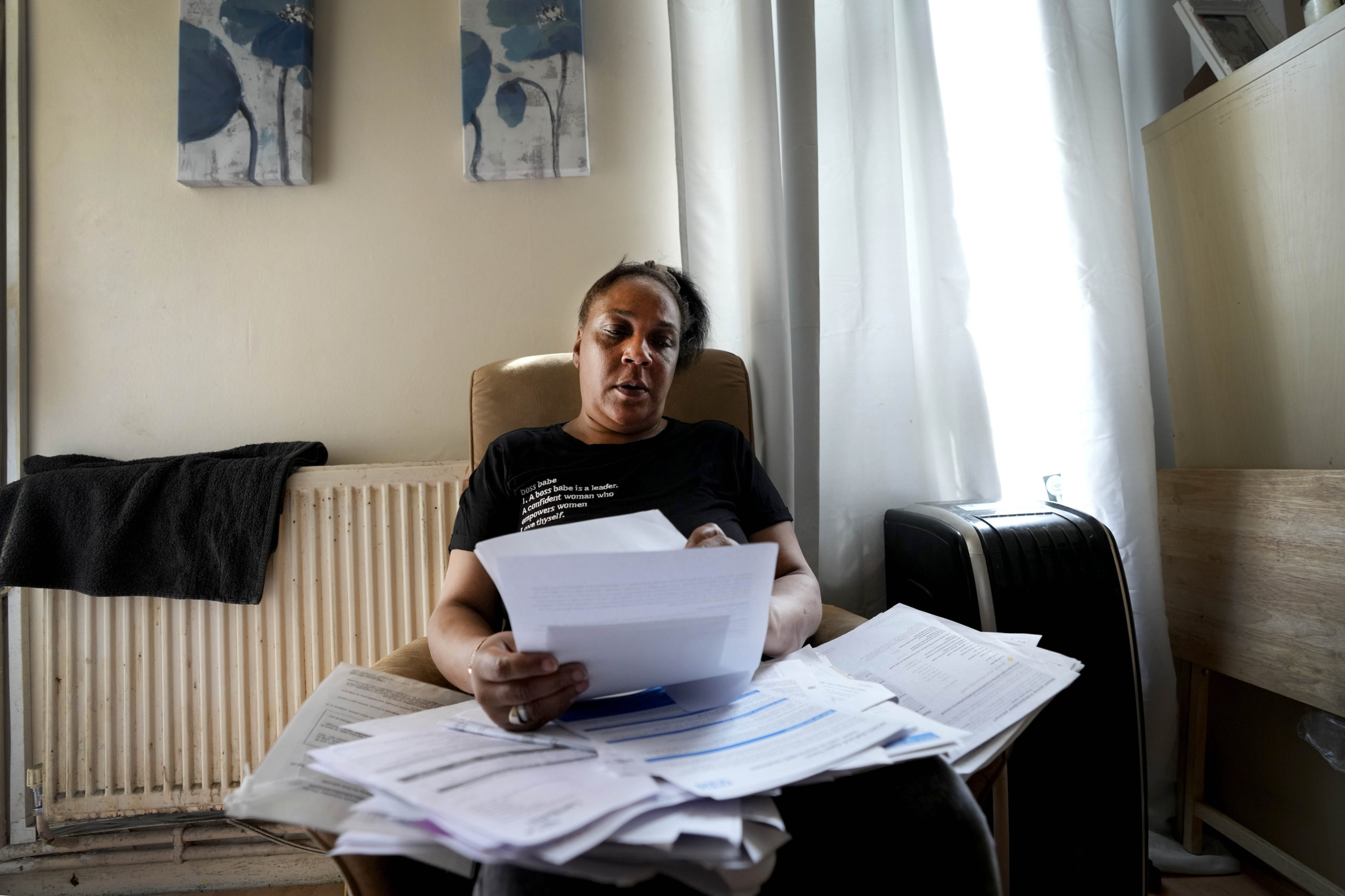 Jennifer Jones sorts her bills at her small flat in London on Thursday. Like millions of people, Jones, 54, is struggling to cope as energy and food prices skyrocket in Great Britain.