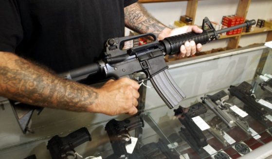An employee of Dave's Guns holds a Colt AR-15 on Sept. 13, 2004, in Denver.
