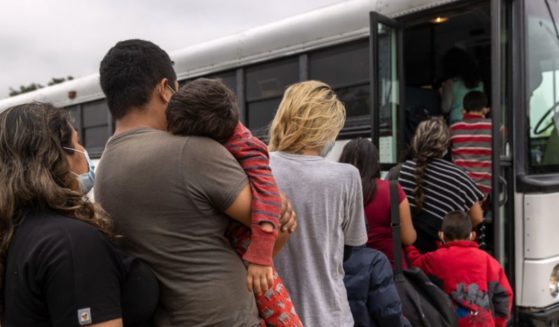 Central American families board a U.S. Customs and Border Protection bus for transport to an immigrant processing center after crossing the border from Mexico in April 2021.