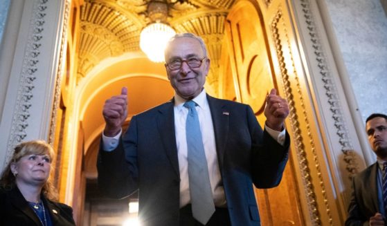 Senate Majority Leader Chuck Schumer gives the thumbs up as he leaves the Senate Chamber after the passing of the Inflation Reduction Act on Sunday in Washington, D.C.
