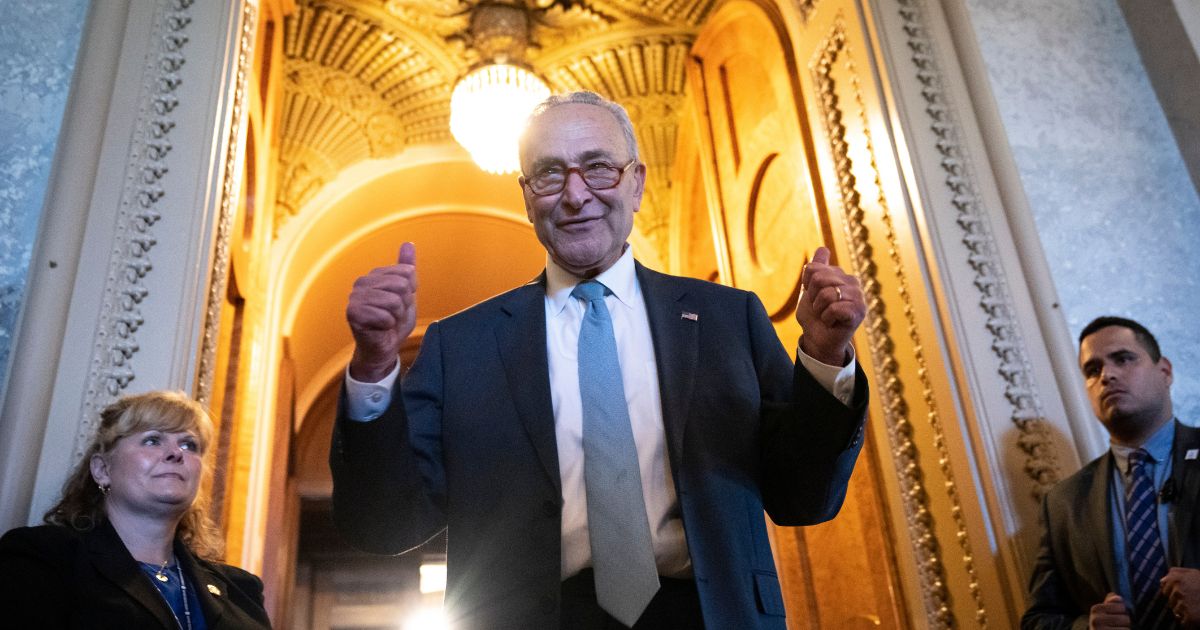 Senate Majority Leader Chuck Schumer gives the thumbs up as he leaves the Senate Chamber after the passing of the Inflation Reduction Act on Sunday in Washington, D.C.