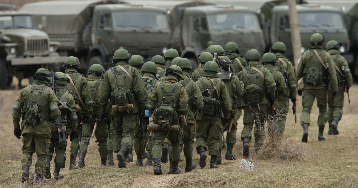 Soldiers who were among several hundred that took up positions around a Ukrainian military base walk towards their parked vehicles on March 2, 2014, in Perevalne, Ukraine.