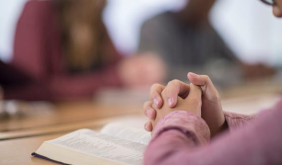 Students pray in this stock image.