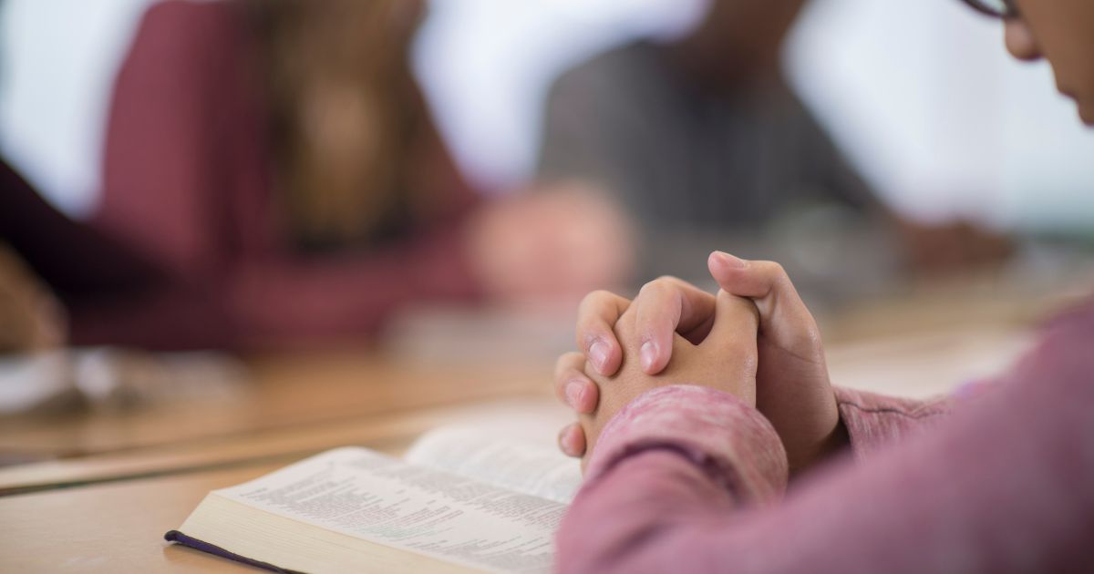 Students pray in this stock image.