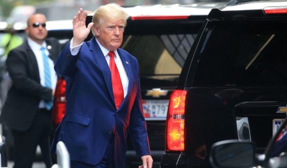 Former President Donald Trump waves while walking to a vehicle outside of Trump Tower in New York City on Wednesday.
