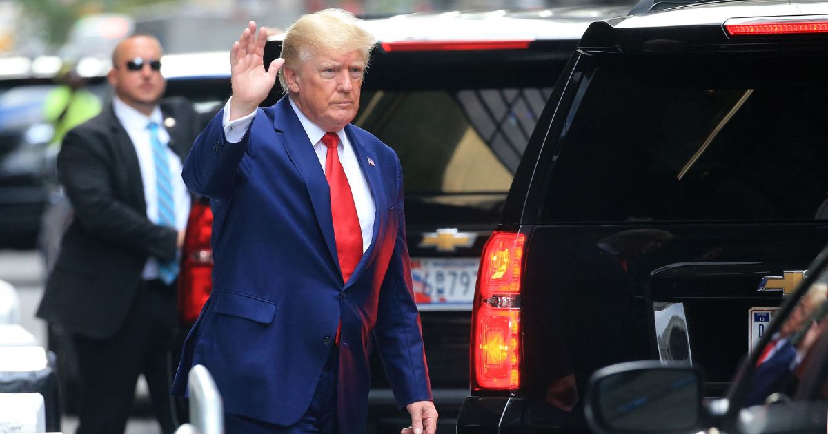 Former President Donald Trump waves while walking to a vehicle outside of Trump Tower in New York City on Wednesday.