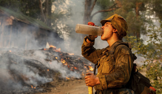 Firefighter Trapper Gephart of Alaska's Pioneer Peak Interagency Hotshot crew takes a drink while battling the Mosquito Fire in the Volcanoville community of El Dorado County, California, on Friday.