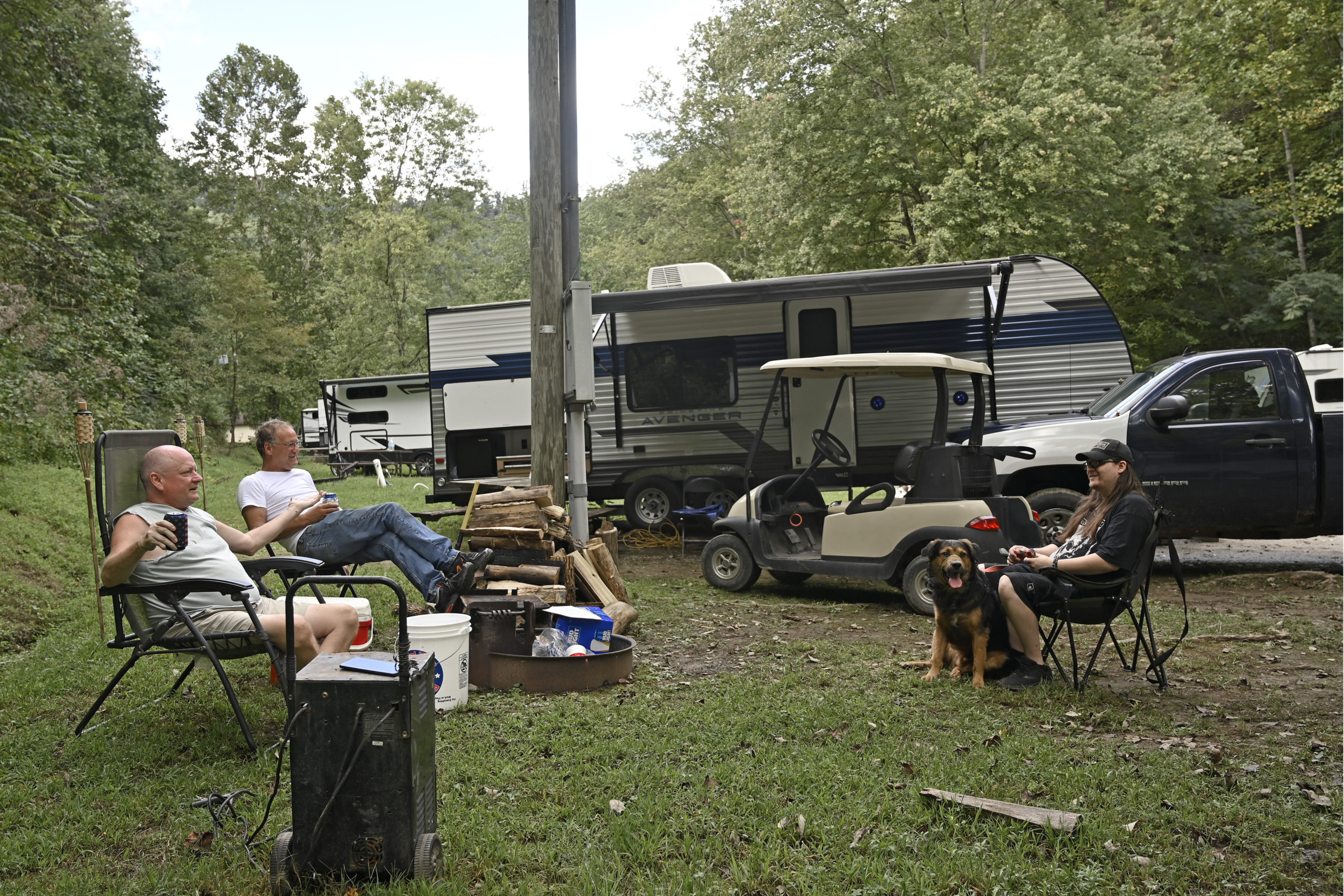 People displaced by floods in early July sit at their campsite at a state park in Prestonsburg, Kentucky, on Tuesday. The flood victims have been staying in travel trailers as they wait for workers to rebuild their homes.
