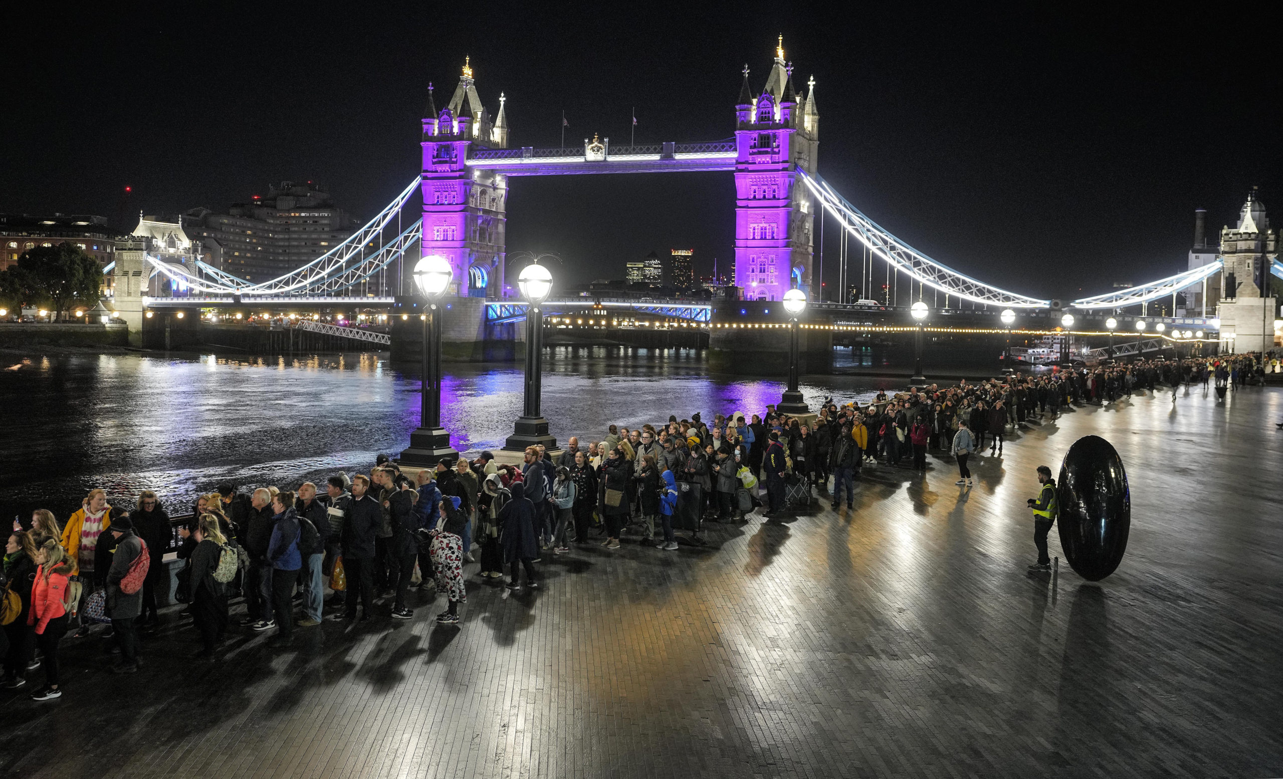 People queue in front of London's Tower Bridge early Saturday morning to pay their respects to the late Queen Elizabeth II at Westminster Hall. Waiting time in the queue has stretched to as long as 24 hours.