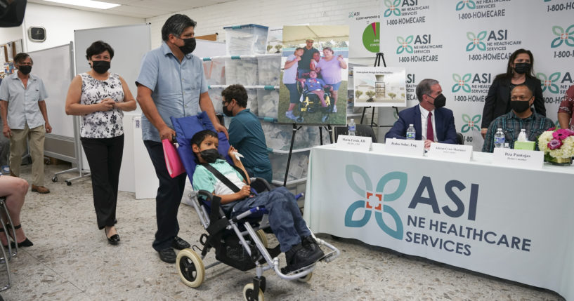 In this photo provided by Clifford Law Offices, Karina Aguilar, her husband, Temo, and their son Felipe attend a news conference on Aug. 3, 2021, at the office of ASI/NE Healthcare Services in Chicago.