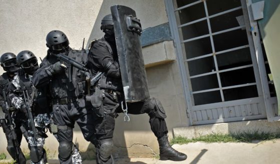 A SWAT team prepares to breach a building.
