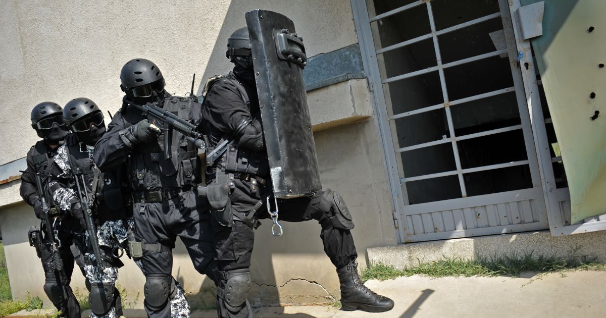 A SWAT team prepares to breach a building.