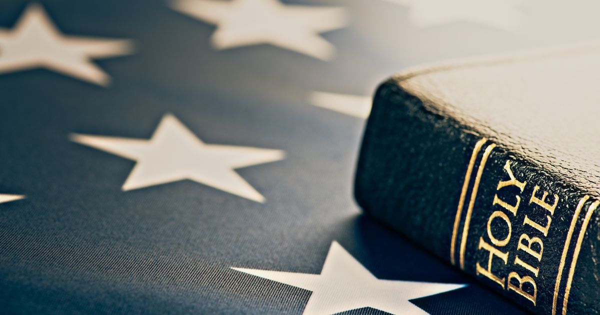 A Bible rests on an American flag in the above stock image.