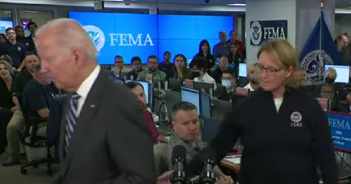FEMA Administrator Deanne Criswell tries to redirect President Joe Biden as he shuffles away from the podium