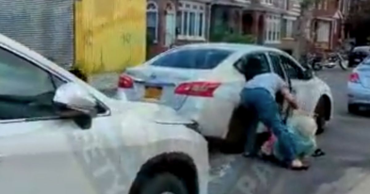A bystander filmed and jumped in to save a 78-year-old woman who was pulled out of the back seat of a car and allegedly robbed by a hired driver in New York City.