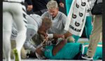 Miami Dolphins quarterback Tua Tagovailoa is examined on the field after an injury during the second quarter of the team's NFL football game against the Cincinnati Bengals Thursday in Cincinnati.
