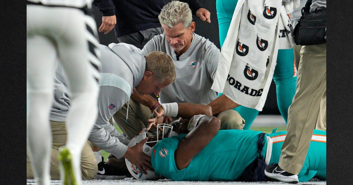 Miami Dolphins quarterback Tua Tagovailoa is examined on the field after an injury during the second quarter of the team's NFL football game against the Cincinnati Bengals Thursday in Cincinnati.