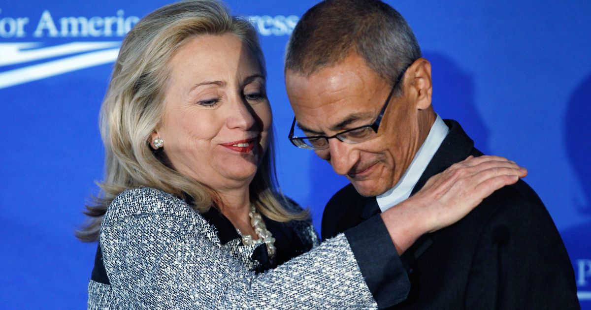 John Podesta, right, hugs then-Secretary of State Hillary Clinton, left, before addressing the "American Idea: A More Perfect Union" conference in Washington, D.C, on Oct. 12, 2011.