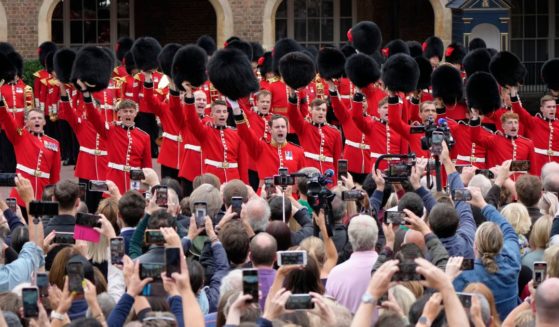 Members of the public gather as military personnel offer three cheers to the new king at St James's Palace in London on Saturday.