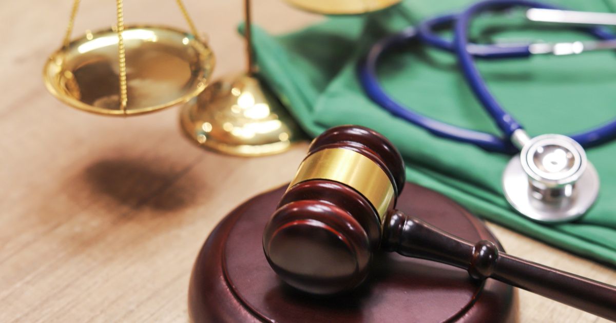 A medical justice concept image features a judge's gavel, a stethoscope and the scales of justice.