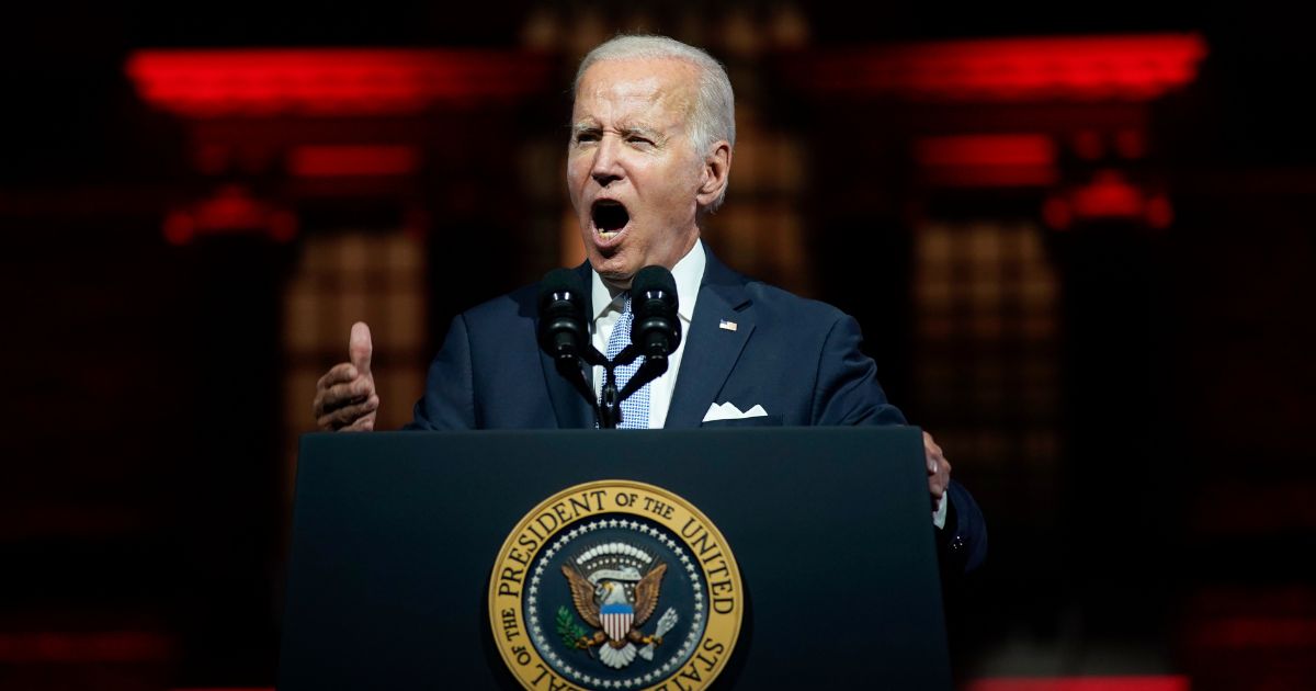 U.S. President Joe Biden speaks in front of ominous red lighting