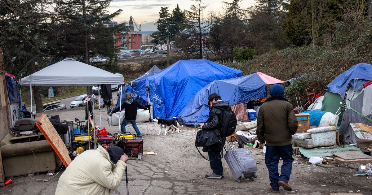 People walk through a homeless encampment in Seattle after smoking fentanyl on March 11.
