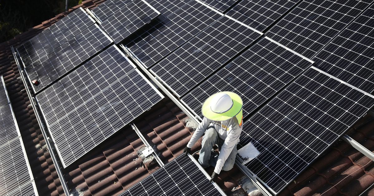 A worker installs a solar panel system on the roof of a home in Palmetto Bay, Florida, in a file photo from January 2018. Many U.S. homeowners are spending tens of thousands of dollars to install solar power in their homes, but some have encountered unexpected problems.